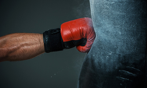 Boxing glove hitting punch bag