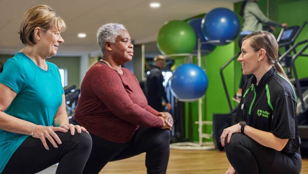 A personal trainer supporting two women